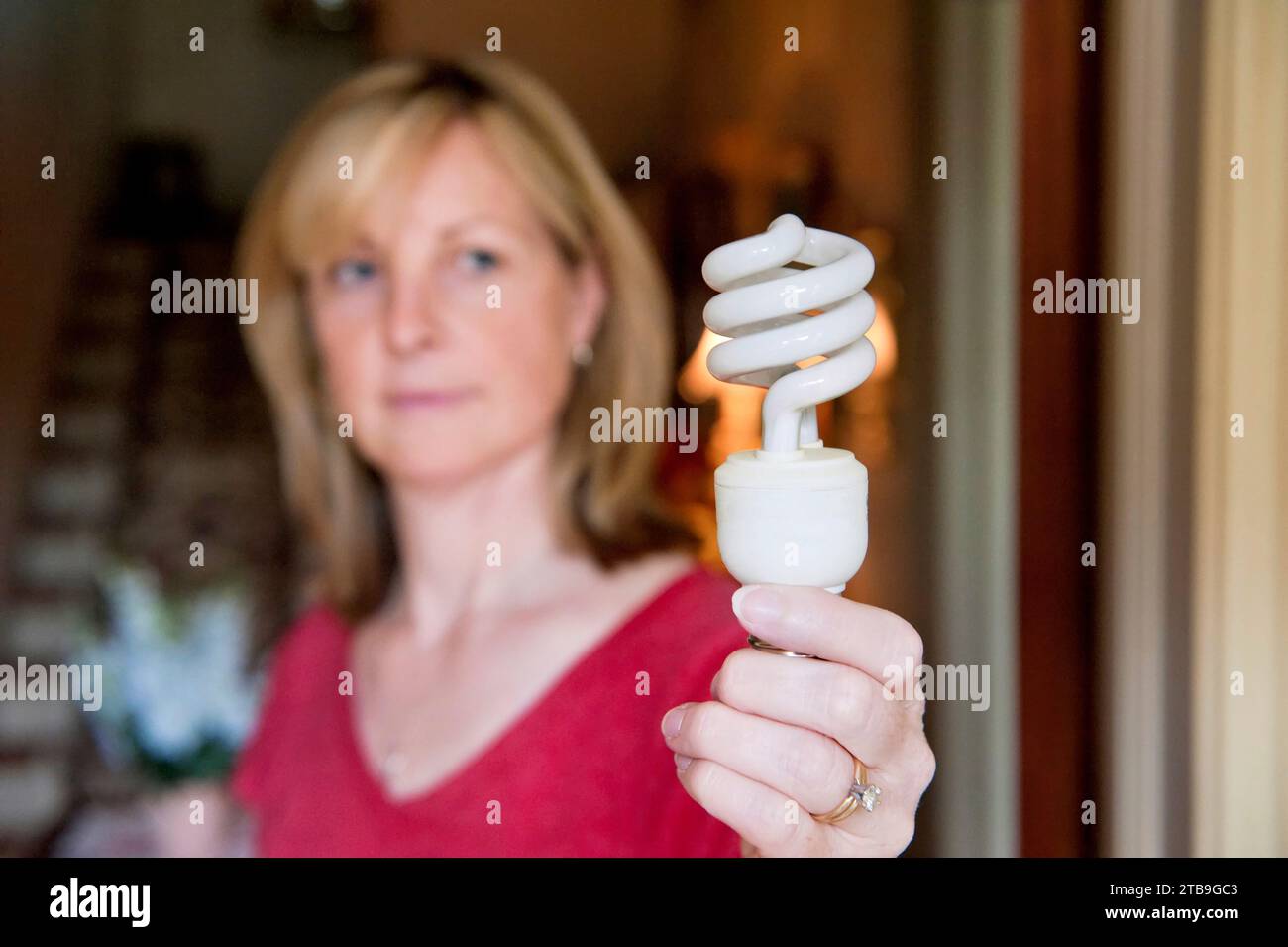 Frau mit einer Energiesparlampe; Lincoln, Nebraska, Vereinigte Staaten von Amerika Stockfoto