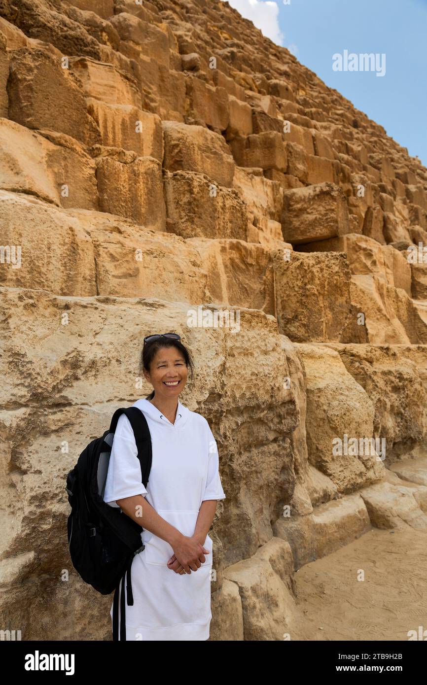 Nahaufnahme einer asiatischen Touristenfrau, die vor der Großen Pyramide von Gizeh steht; Gizeh, Kairo, Ägypten Stockfoto