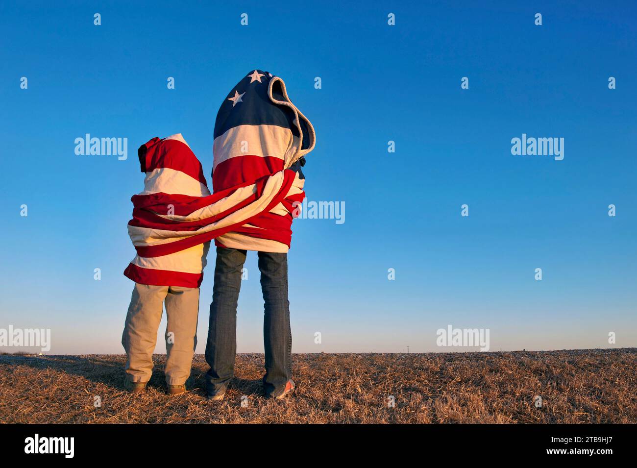 Zwei Personen, die in eine amerikanische Flagge gewickelt sind: Lincoln, Nebraska, Vereinigte Staaten von Amerika Stockfoto