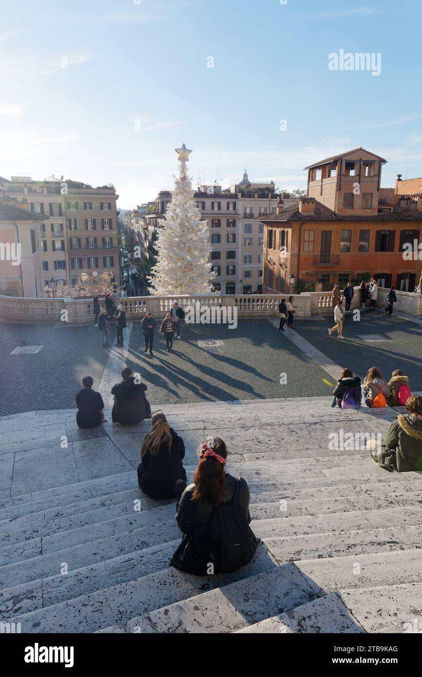 Die Menschen sitzen an einem Herbsttag mit einem weißen Weihnachtsbaum auf der berühmten Spanischen Treppe in Rom, Region Latium, Italien, 05. Dezember 2023 Stockfoto