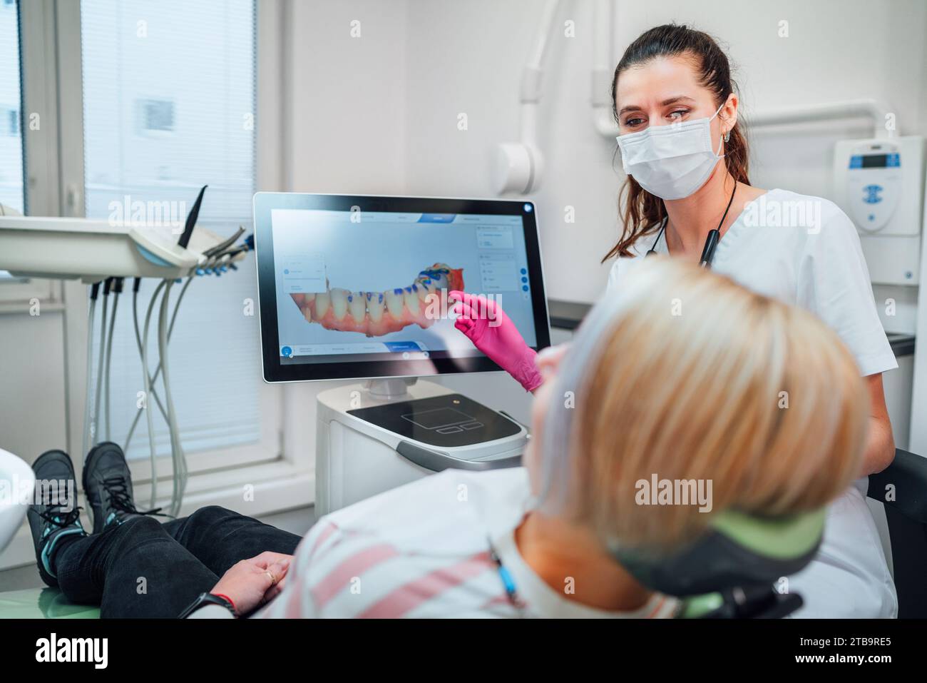 Zahnarztin in Uniform mit Scan des intraoralen 3D-Dentalscanners Maschine zum Patienten. Zahnärztlicher Klinikpatient besucht moderne medizinische Station. Reparieren Stockfoto