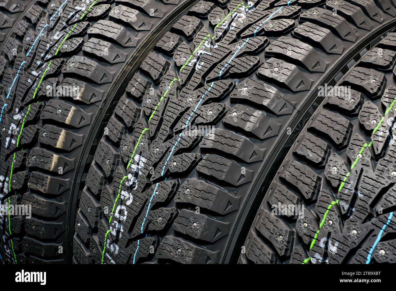 Mit neuen Winterreifen versehener Hintergrund, Schneeräder mit Metallbolzen Stockfoto