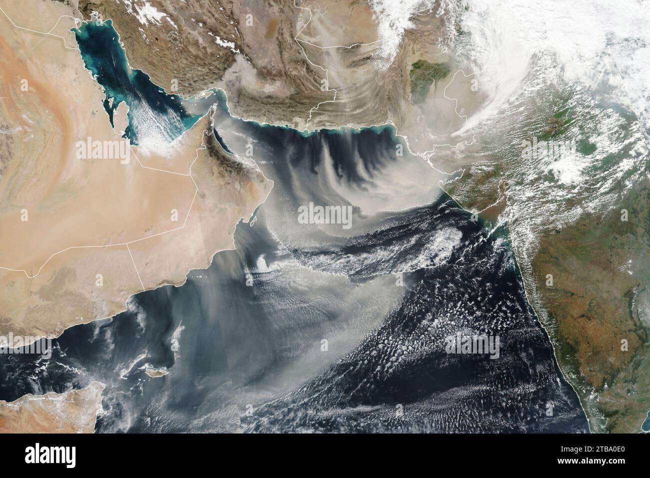 Satellitenansicht von Staubwolken, die aus Oman, Pakistan und Iran ins Arabische Meer strömen. Stockfoto