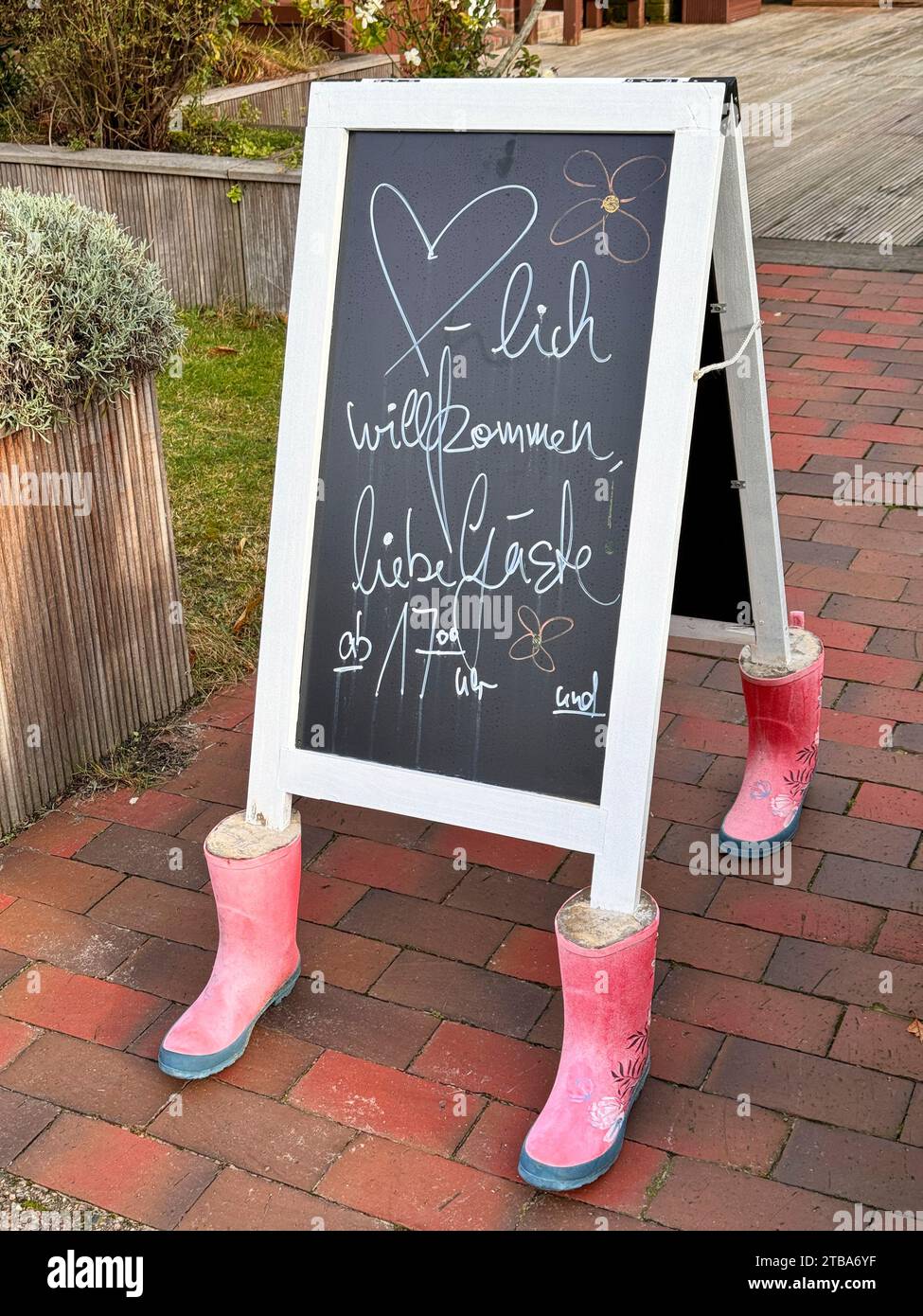 Tafel eines Restaurants, beschwert mit Gummistiefeln, die mit Beton gefüllt sind, Nordseeinsel Spiekeroog, Ostfriesland, Niedersachsen, Deutschland, Stockfoto