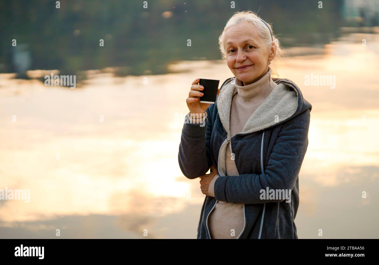 Eine Frau, Dame trinkt einen Kaffee und genießt den Sonnenuntergang. Stockfoto
