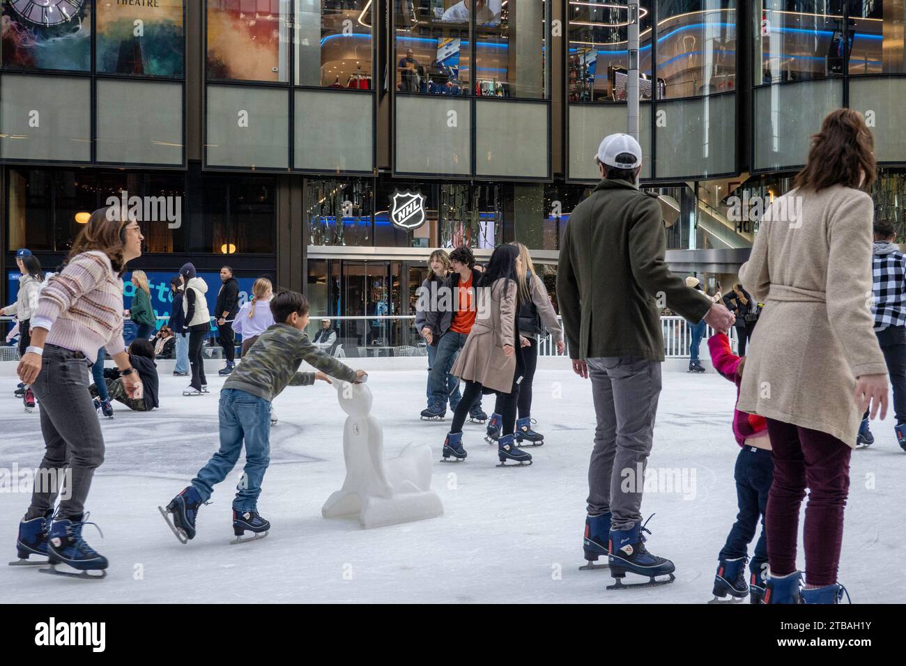 Eine öffentliche Eislaufbahn befindet sich vor dem National Hockey League Store in New York City, USA 2023 Stockfoto