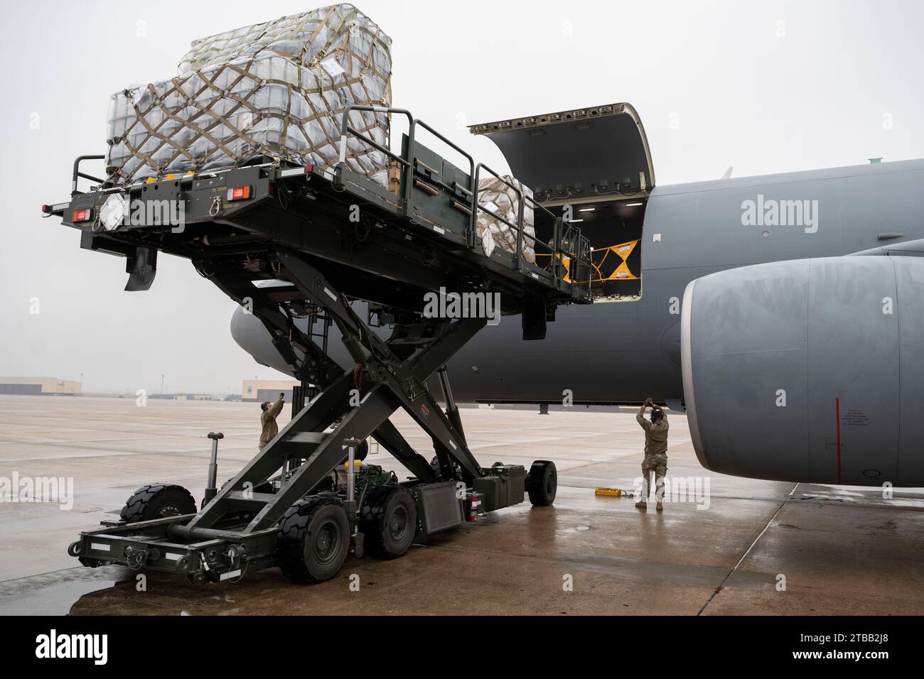 Mitglieder der US-Luftwaffe, die der 509th Logistics Readiness Squadron zugewiesen wurden, transportierten Vorräte, die auf ein KC-46 Pegasus-Flugzeug geladen wurden, das der 18th Air Betankungeschwader auf der Whiteman Air Force Base, Mo., 1. Dezember 2023 zugewiesen wurde. Dies war der erste Fracht-Upload einer KC-46 bei Whiteman AFB. Der Fracht-Upload wurde zur Unterstützung des Denton Humanitarian Assistance Program durchgeführt. (Foto der U.S. Air Force von Tech. Anthony Hetlage) Stockfoto