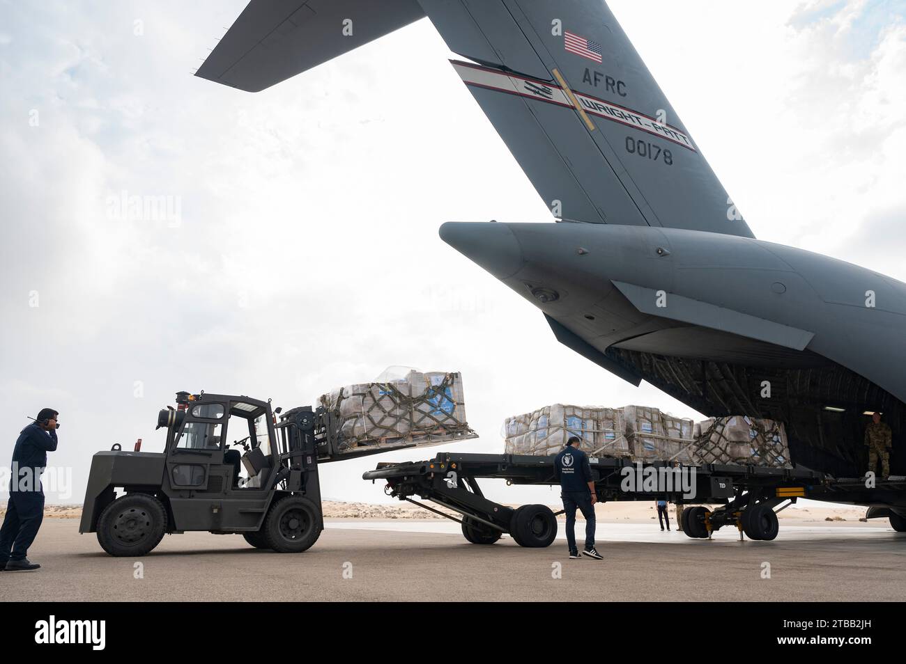 Luftwaffenflugzeuge der US Air Force entladen humanitäre Hilfe von einem C-17 Globemaster III auf einem nicht offengelegten Flugplatz im Nahen Osten, 5. Dezember 2023. Die US-Regierung arbeitet mit dem Welternährungsprogramm der Vereinten Nationen (WFP) und dem Hilfswerk der Vereinten Nationen für Palästinaflüchtlinge im Nahen Osten (UNRWA) zusammen. (Foto der U.S. Air Force von Staff Sgt. Daniel Hernandez) Stockfoto