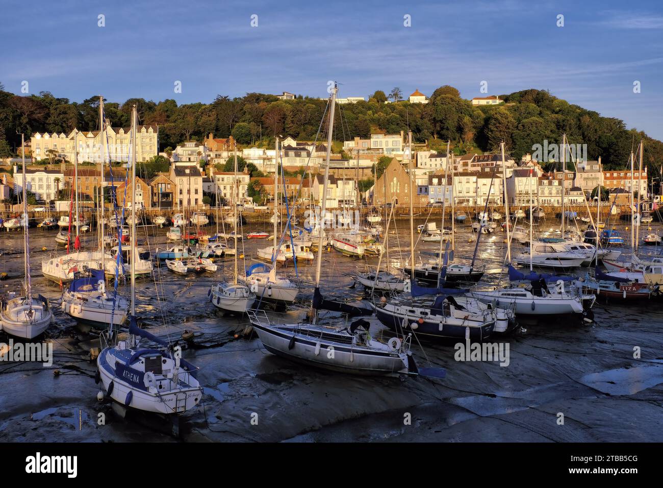 St Aubin: Yachten und Boote im Hafen mit Kirche und Somerville Hotel kurz nach Sonnenaufgang in St Aubin, Kanalinseln, Großbritannien Stockfoto