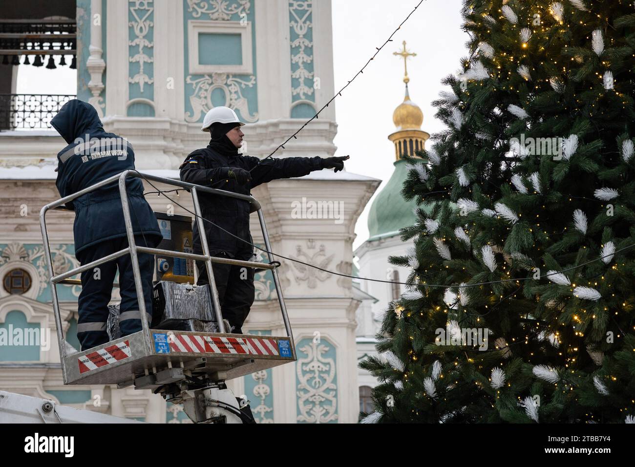 Stadtarbeiter bauen einen Weihnachtsbaum auf dem Sophia-Platz im Zentrum von Kiew. Aufgrund des Krieges und eines begrenzten Budgets installierten die Kiewer Behörden einen kleinen Weihnachtsbaum. In der Nähe des Weihnachtsbaums und der nahegelegenen Plätze werden jedoch keine traditionellen Feiertagsmessen stattfinden, und am Silvesterabend wird es eine Ausgangssperre geben. Im Gegensatz zu früheren Jahren, als die Ukraine am 7. Januar zusammen mit anderen postsowjetischen Ländern Weihnachten feierte, wird sie sich dieses Jahr mit Europa verbinden und Weihnachten am 25. Dezember feiern. (Foto: Oleksii Chumachenko/SOPA Images/SIPA USA) Stockfoto