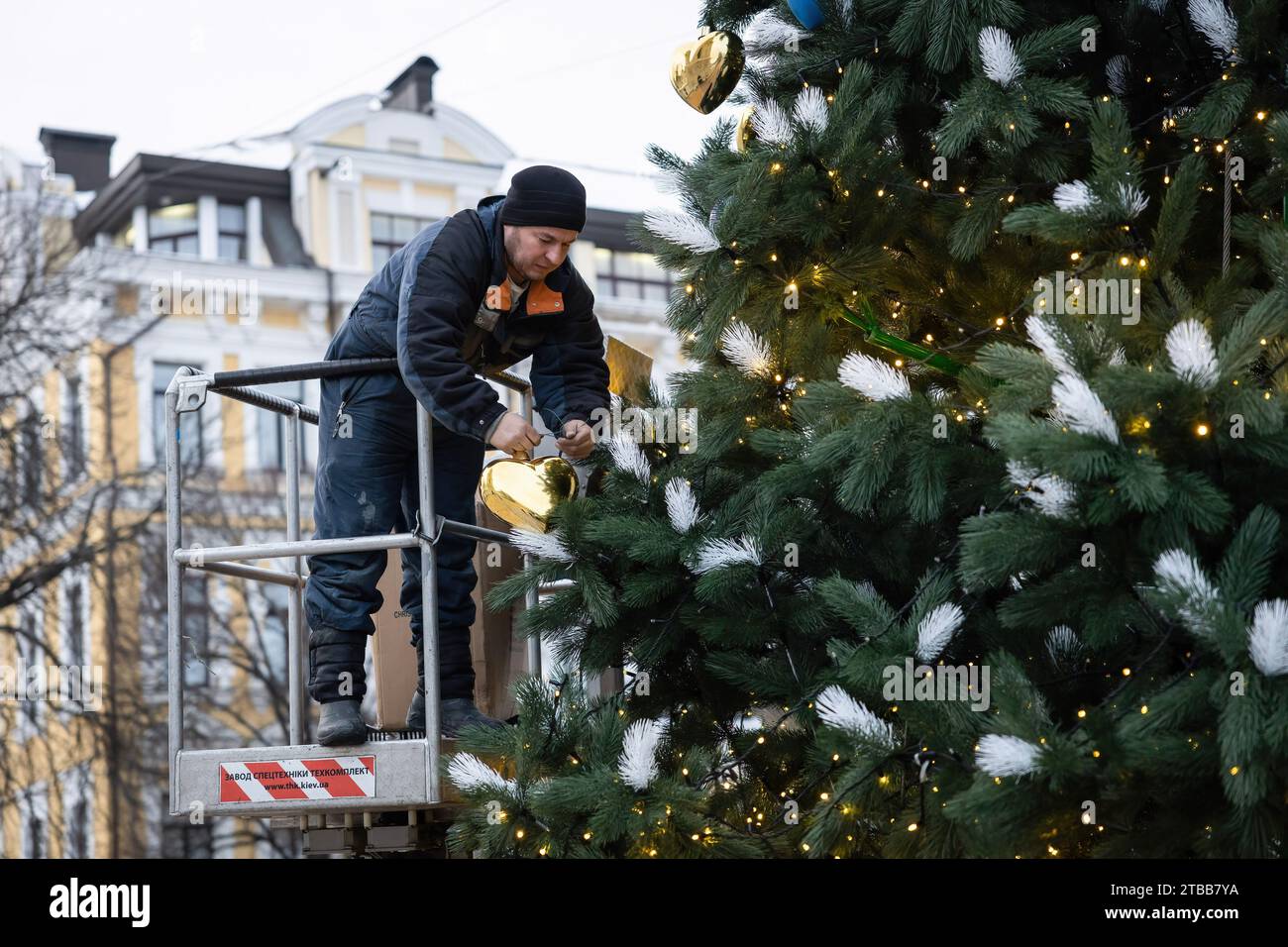 Kiew, Ukraine. Dezember 2023. Ein Gemeindearbeiter installiert einen Weihnachtsbaum auf dem Sophia-Platz im Zentrum von Kiew. Aufgrund des Krieges und eines begrenzten Budgets installierten die Kiewer Behörden einen kleinen Weihnachtsbaum. In der Nähe des Weihnachtsbaums und der nahegelegenen Plätze werden jedoch keine traditionellen Feiertagsmessen stattfinden, und am Silvesterabend wird es eine Ausgangssperre geben. Im Gegensatz zu früheren Jahren, als die Ukraine am 7. Januar zusammen mit anderen postsowjetischen Ländern Weihnachten feierte, wird sie sich dieses Jahr mit Europa verbinden und Weihnachten am 25. Dezember feiern. Quelle: SOPA Images Limited/Alamy Live News Stockfoto