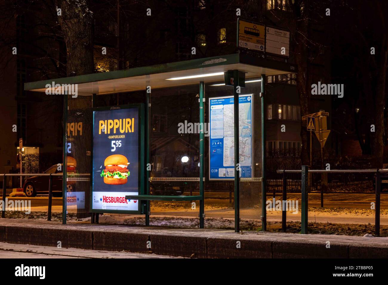 Die Straßenbahnhaltestelle Munkkiniemen aukio befindet sich nach Einbruch der Dunkelheit im Stadtteil Munkkiniemi in Helsinki, Finnland Stockfoto