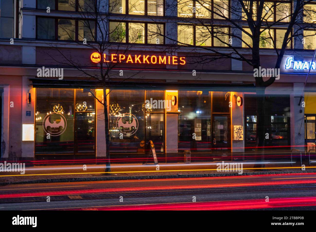 Tauchbar und Musikstätte Lepakkomies in Helsinginkatu 1 nach Einbruch der Dunkelheit mit leichten Pfaden vorbeifahrender Fahrzeuge im Bezirk Harju in Helsinki, Finnland Stockfoto