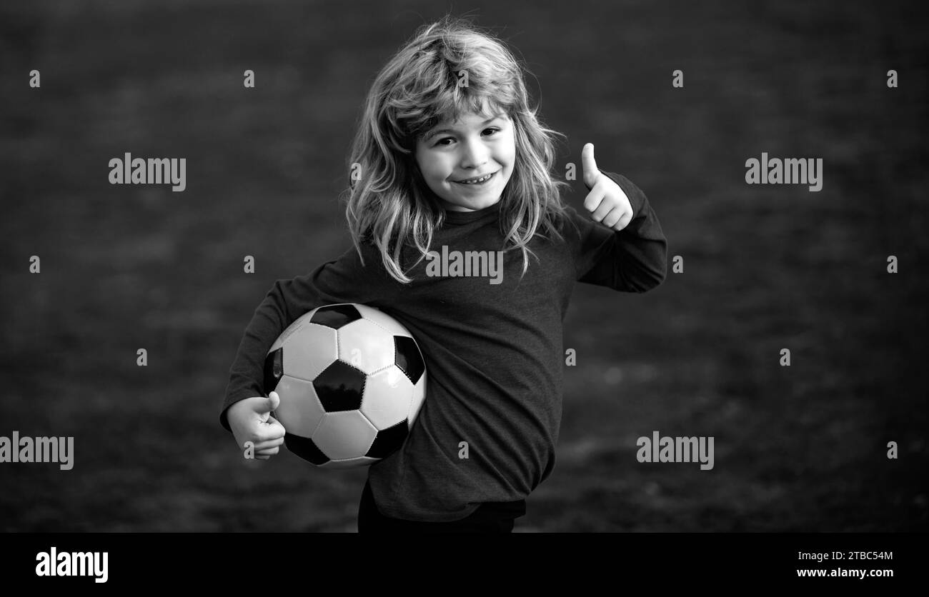 Fußball Kind Junge Fußball spielen. Kind Junge spielen Fußball auf Freigelände zeigen Daumen nach oben Erfolgsschild . Kinder Tor bei Fußballspiel. Fansport Stockfoto