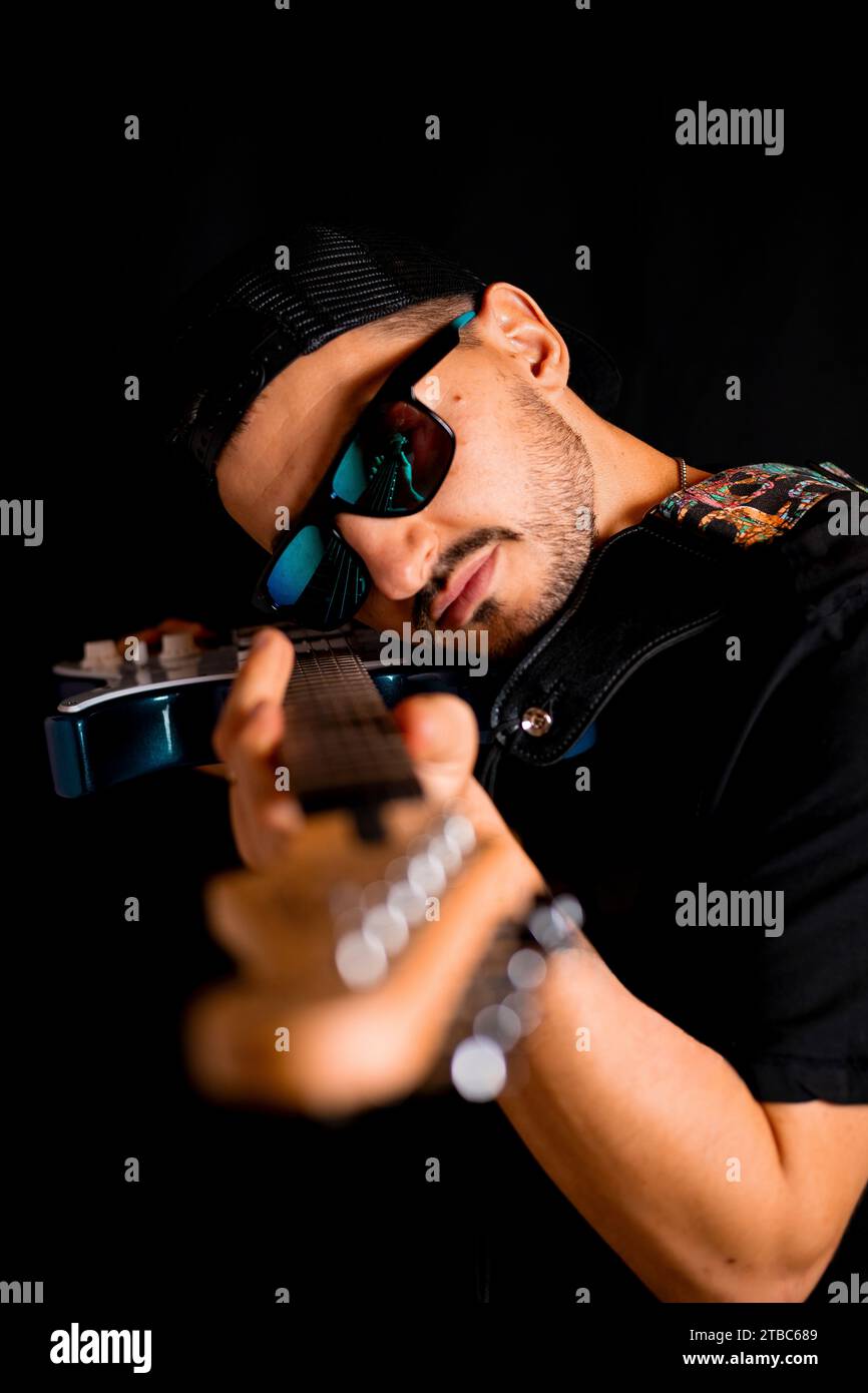 Musiker mit blauer Brille und schwarzer Kappe, der bei der Albumsession durch den Mast schaut Stockfoto