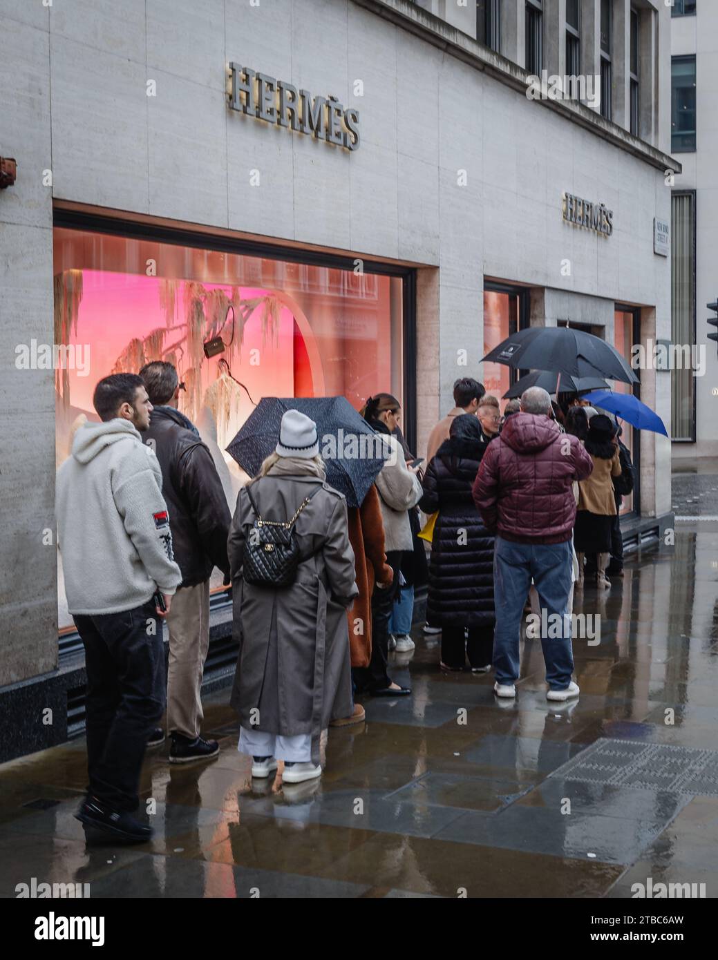 Käufer trotzen dem kalten und nassen Wetter und langen Warteschlangen, um Hermès zu besuchen. Stockfoto