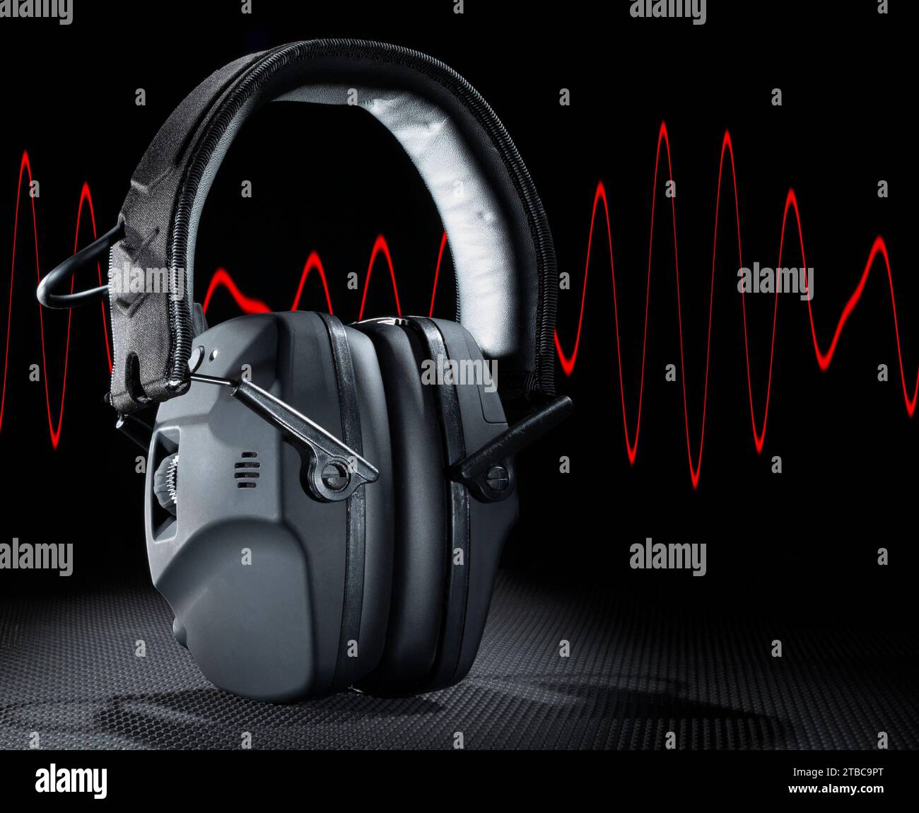 Rote Sinuswelle hinter einem elektronischen Headset, das Gehörschutz bietet Stockfoto