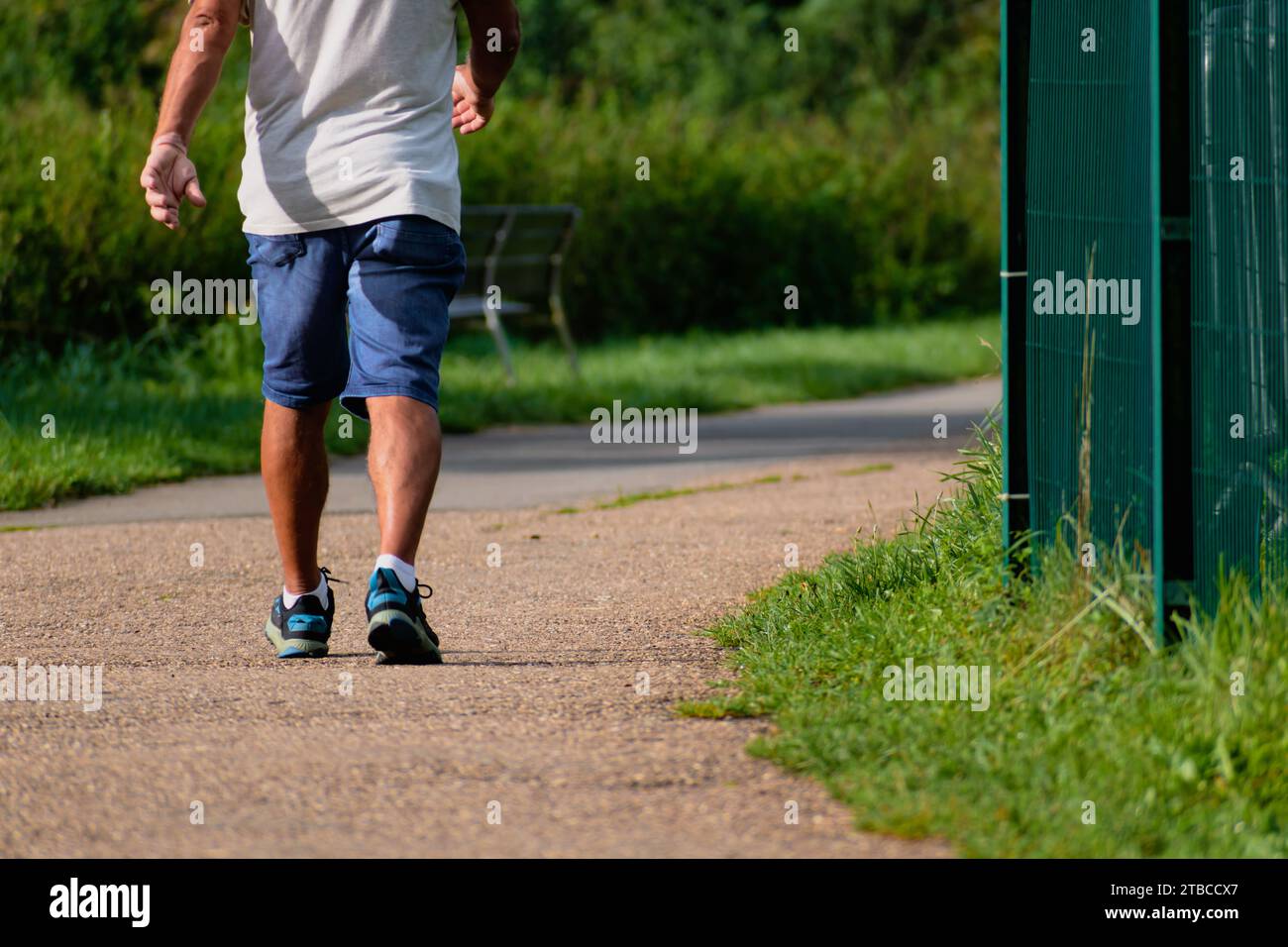 Mann, der mit Turnschuhen auf einem Weg läuft, Nahaufnahme seiner Beine, sportliche Aktivität, gesunde Lebensführung Stockfoto