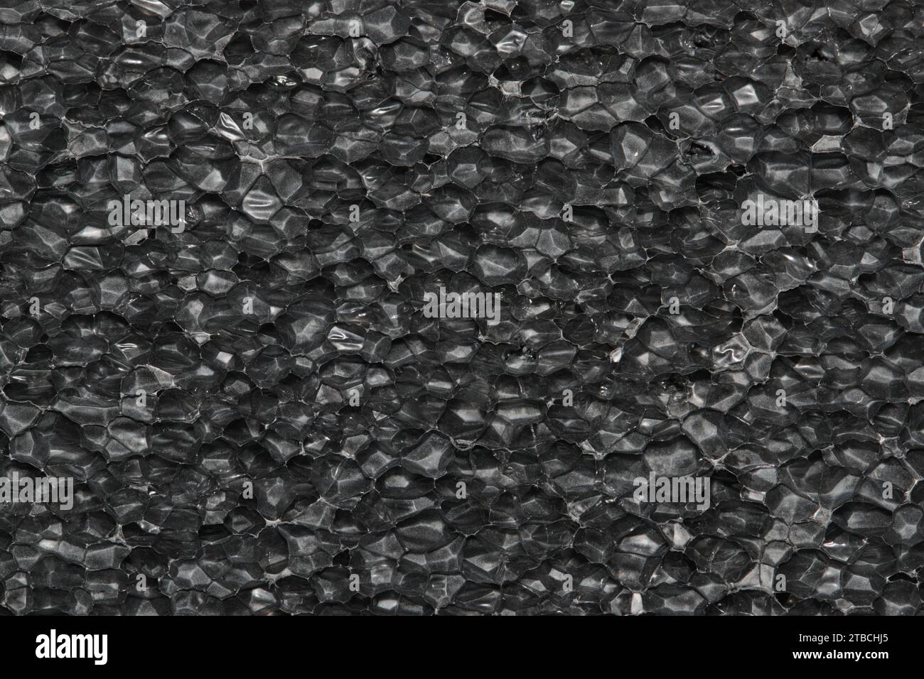 Schwarzer Hintergrund der Probe aus expandiertem Polyethylenschaum. EPE-Perlen Verpackungsmaterial mit Makrodetailzellen, Texturen und einer einfarbigen Farbe. Stockfoto
