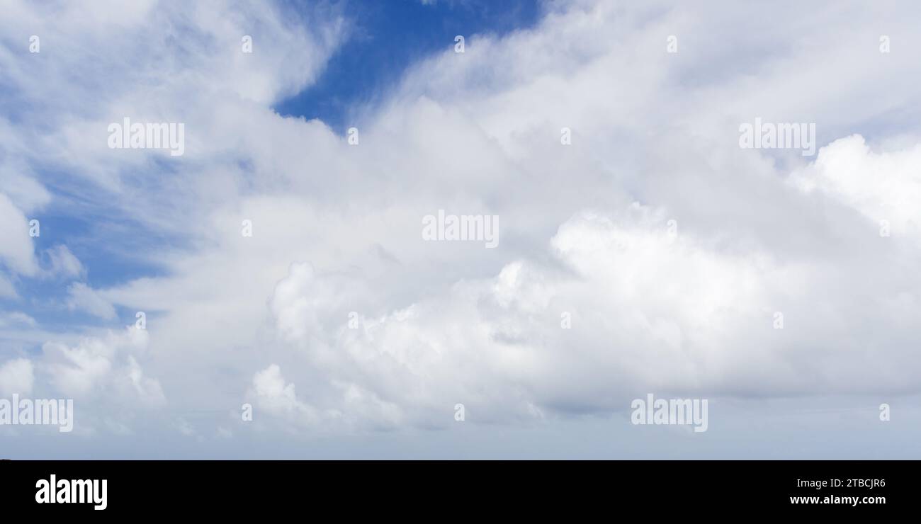 Bewölkter Himmel an einem sonnigen Tag. Natürliches Panorama-Hintergrundfoto. Weiße Cumulus-Wolken sind am blauen Himmel Stockfoto