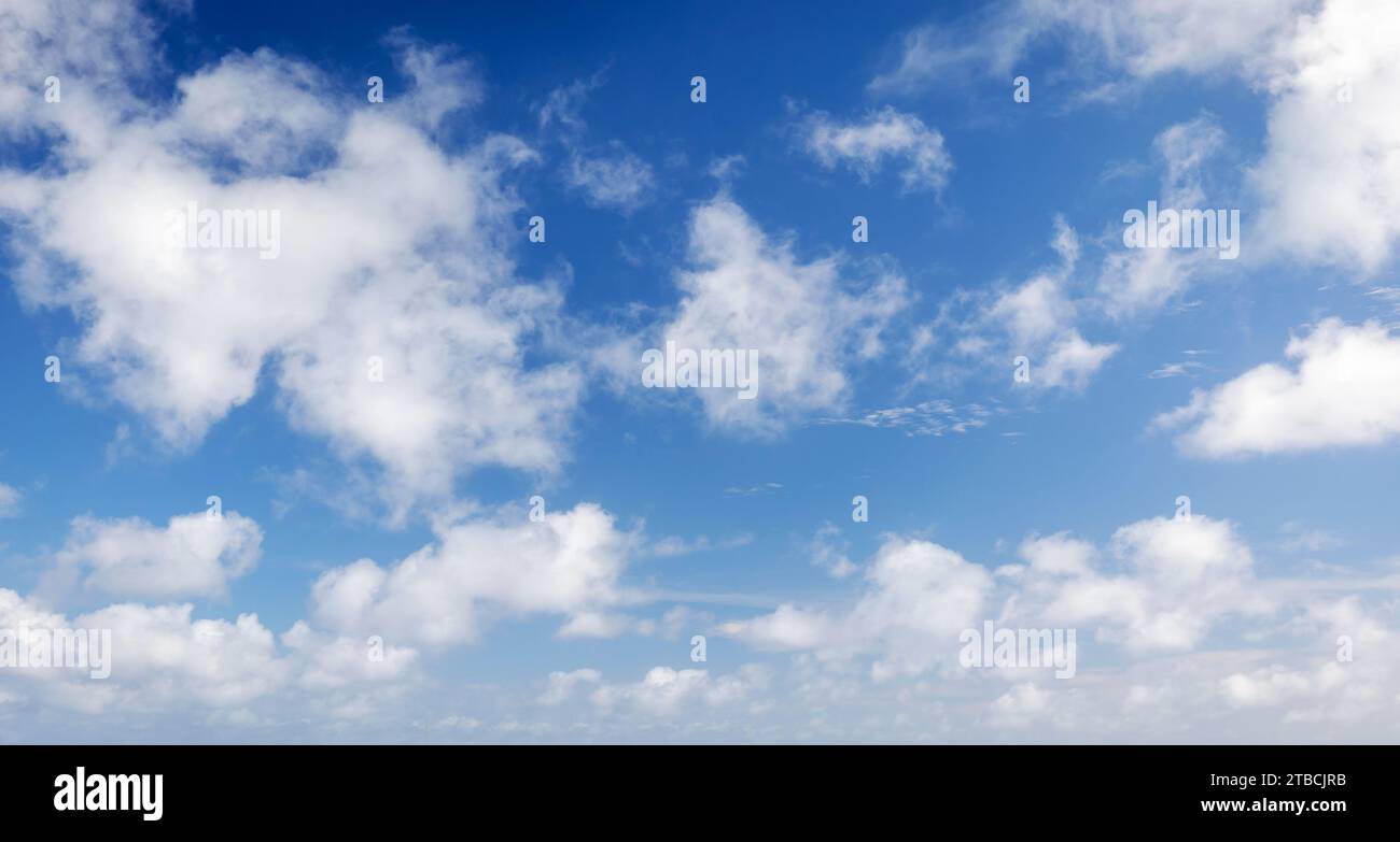 Bewölkter Himmel an einem Tag. Natürliches Panorama-Hintergrundfoto. Die Wolkenarten Cumulus und Altocumulus sind im blauen Himmel Stockfoto