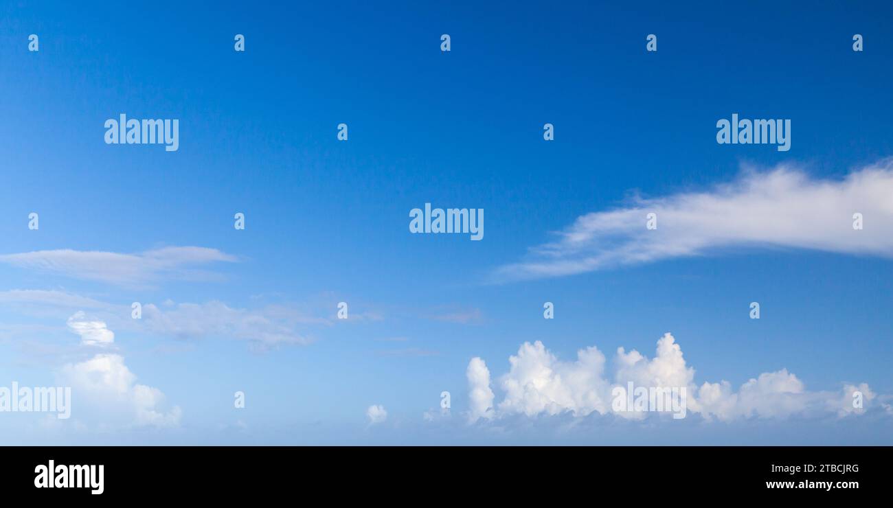 Bewölkter Himmel an einem sonnigen Tag. Natürliches Panorama-Hintergrundfoto. Die Wolkenarten Cumulus und Altocumulus sind im blauen Himmel Stockfoto