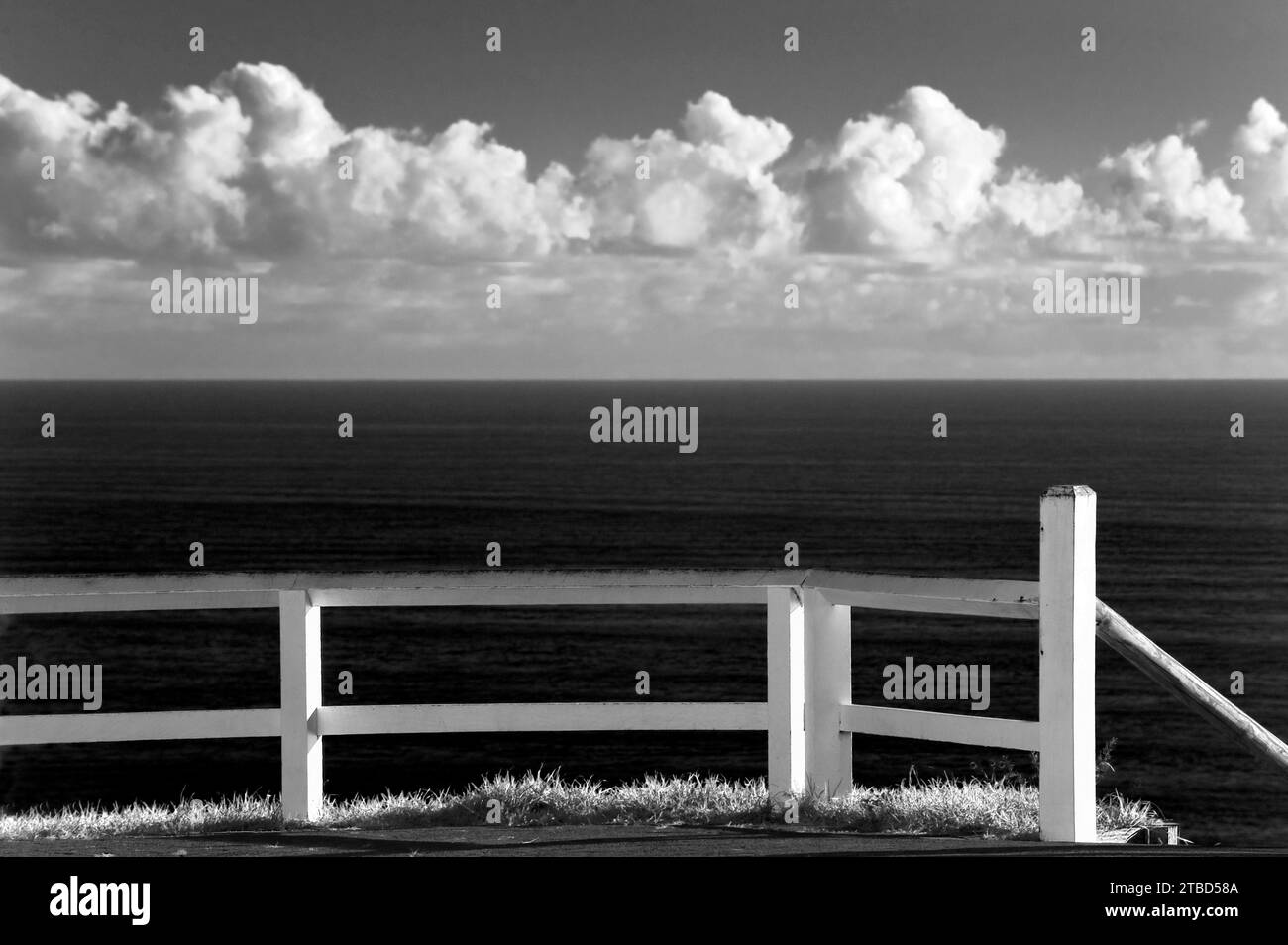 Weißer Zaun, schwarz-weiß, mit bewölktem Himmel, schön, puristisch, leer, Traum, Reise, Urlaub, Symbol, an der Küste von Byron Bay, Australien Stockfoto