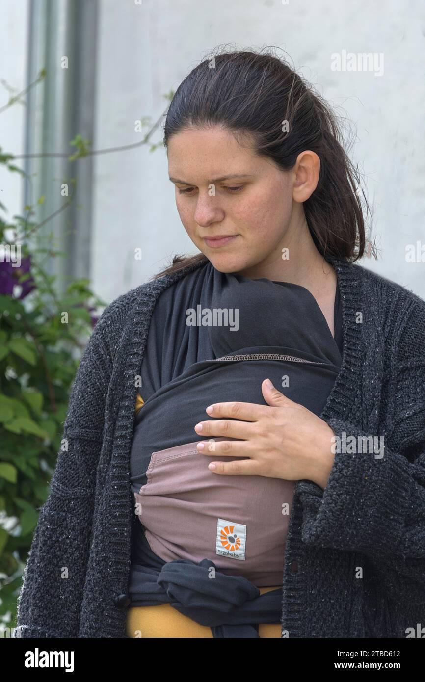 Junge Mutter mit ihrem Baby in einer Schlinge, Mecklenburg-Vorpommern, Deutschland Stockfoto