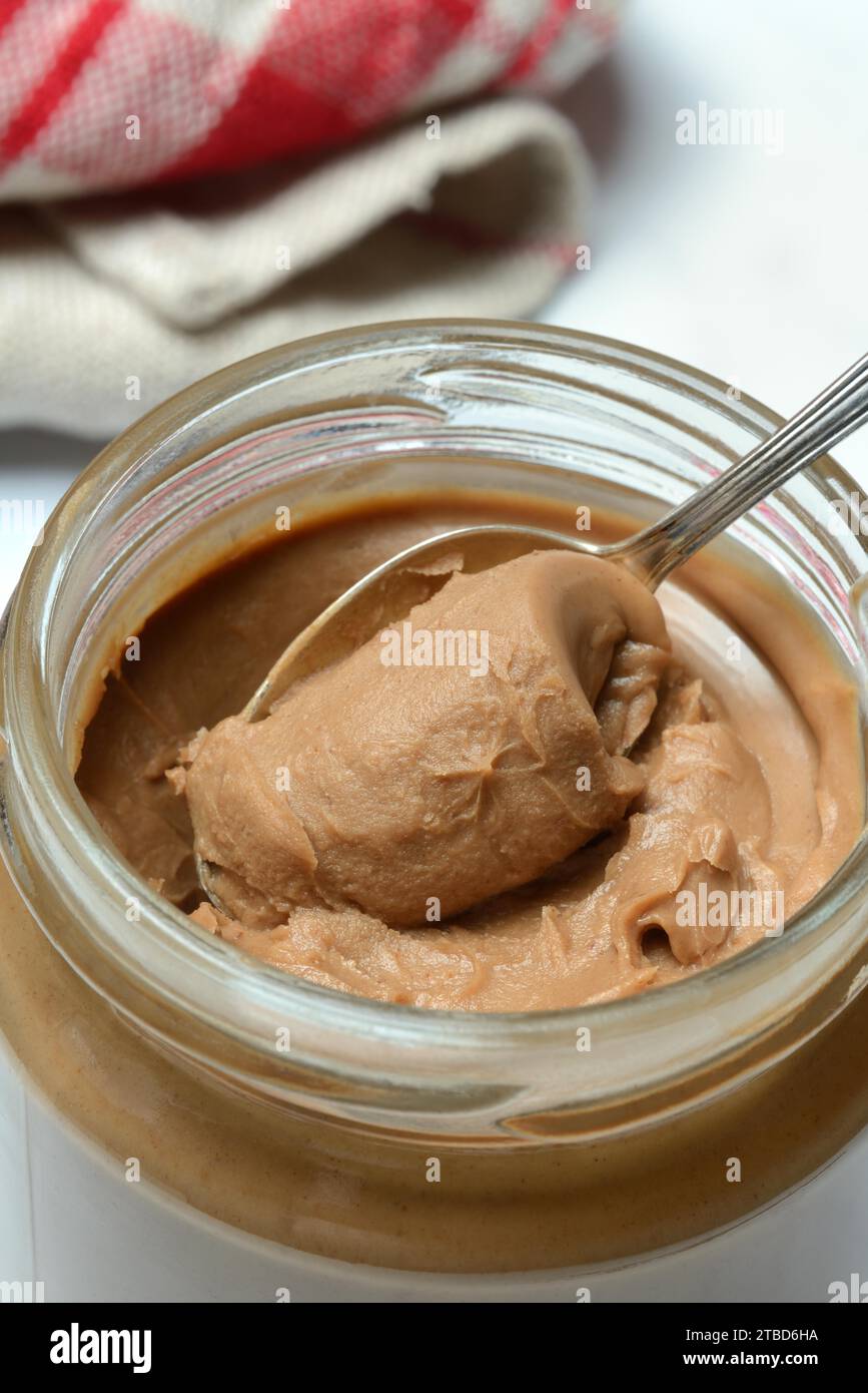 Mandelcreme im Glas mit Löffel, Mandelaufstrich Stockfoto