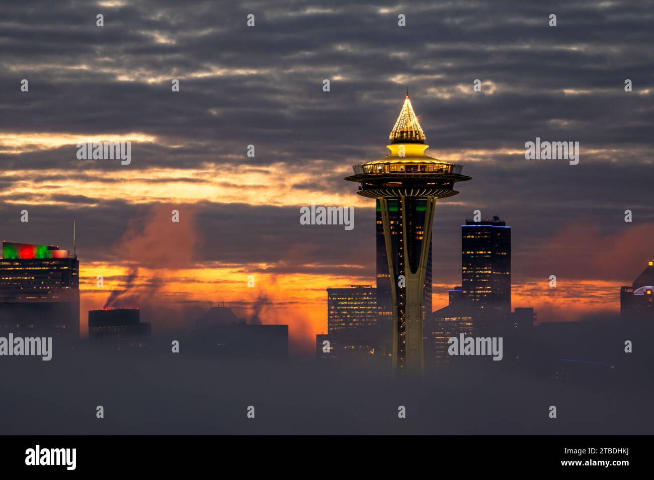 WA23859-00...WASHINGTON - Dawn on a neggy Seattle Morning mit nur der Space Needle und ein paar Hochhäusern in der Morgennebeldecke. Stockfoto