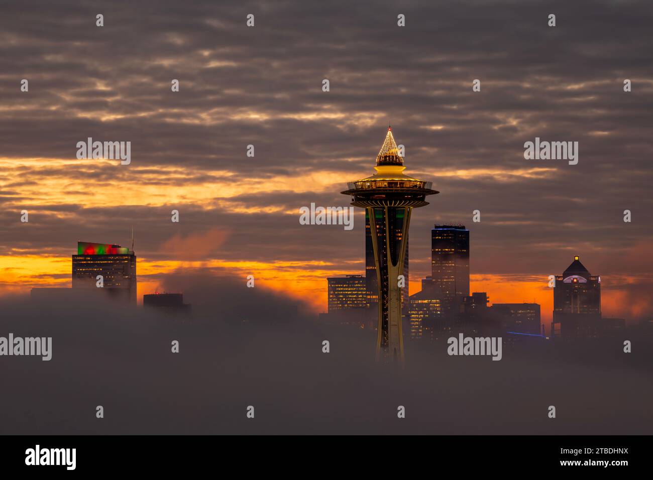 WA23860-00...WASHINGTON - Dawn on a neggy Seattle Morning mit nur der Space Needle und ein paar Hochhäusern in der Morgennebeldecke. Stockfoto