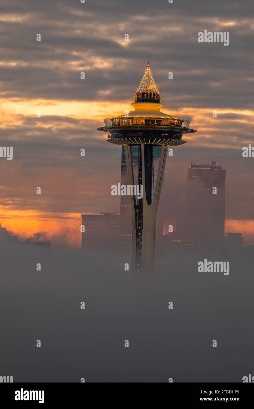 WA23861-00...WASHINGTON - Dawn on a neggy Seattle Morning mit nur der Space Needle und ein paar Hochhäusern in der Morgennebeldecke. Stockfoto