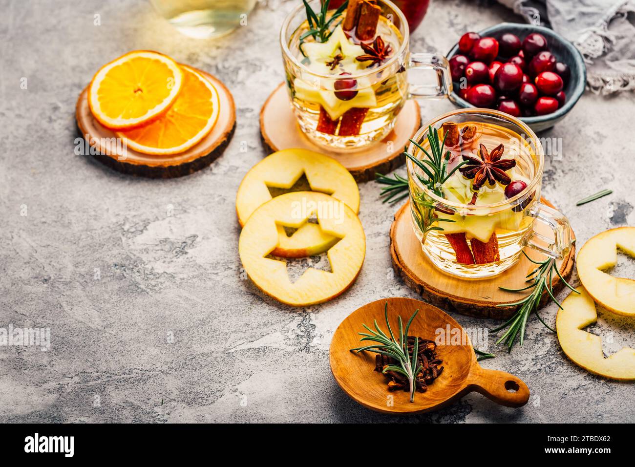 Köstlicher Weißglühwein mit Äpfeln, Preiselbeeren und Gewürzen Stockfoto