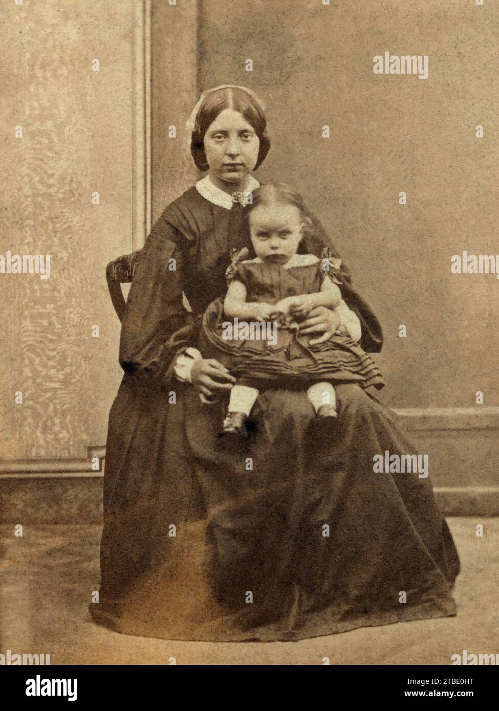 Eine Frau mit einem kleinen Kind auf dem Schoß in einem Liverpool Studio. Stockfoto