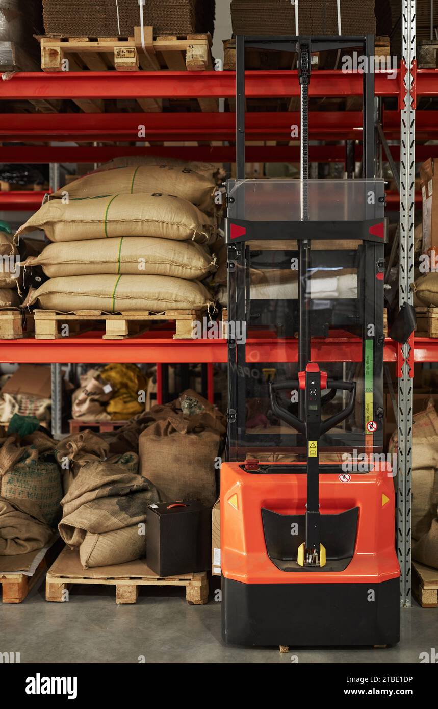 Vertikales Hintergrundbild der Lagerregale mit Kaffeesäcken und Gabelstaplerausrüstung Stockfoto