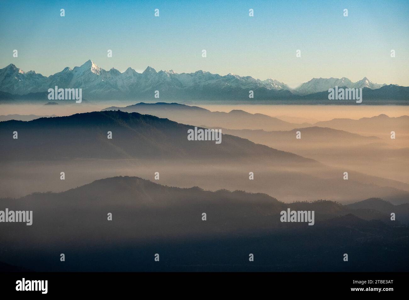 Nebelbedeckte Berge im Vordergrund mit Himalaya-Gebirgszug im Hintergrund, Blick von Pangot, Indien Stockfoto