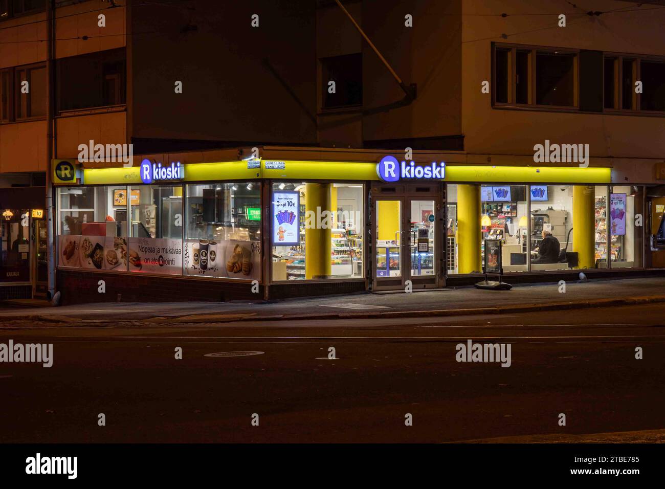 R-kioski nach Einbruch der Dunkelheit an der Ecke Viides linja und Porthaninkatu im Bezirk Kallio in Helsinki, Finnland Stockfoto