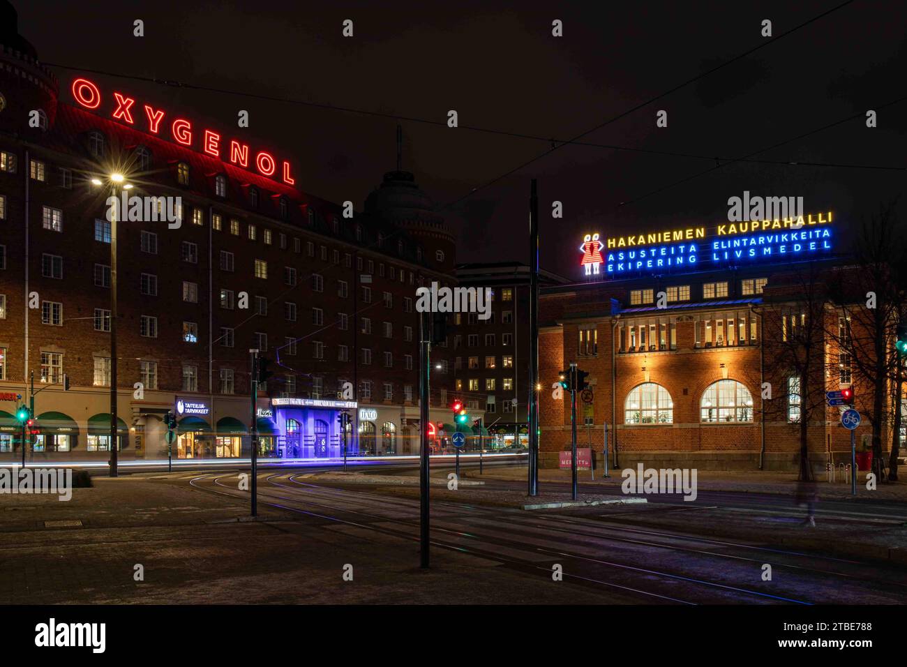 Langzeitbelichtung von Neonlichtern von Oxygenol und Hakaniemen kauppahalli nach Einbruch der Dunkelheit im Bezirk Hakaniemi in Helsinki, Finnland Stockfoto