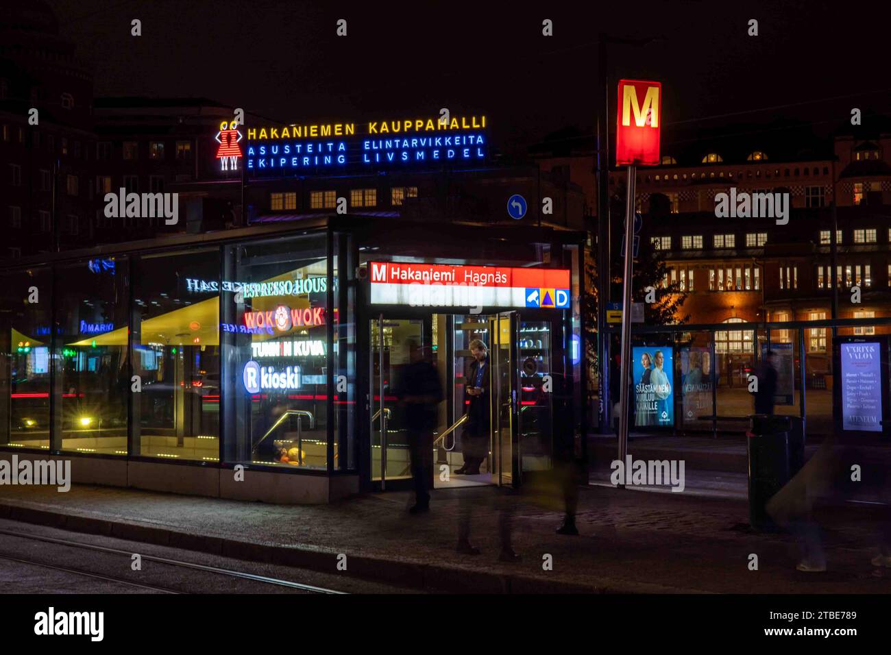 Verschwommene Bewegungen, Neonlichter und Eingang der U-Bahn-Station Hakaniemi nach Einbruch der Dunkelheit im Bezirk Hakaniemi in Helsinki, Finnland Stockfoto