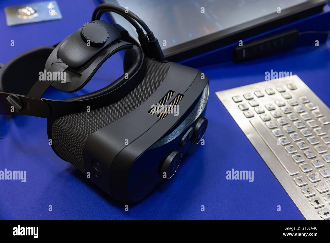 Das VR-Headset liegt auf dem Schreibtisch in der Nähe einer integrierten Tastatur, Nahaufnahme mit selektivem Fokus Stockfoto
