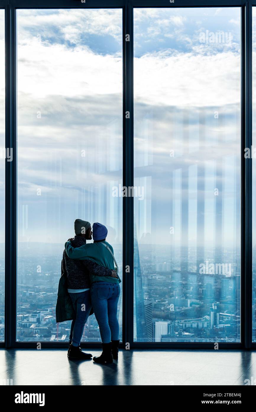 Ein Paar, das die Skyline der Stadt von der Aussichtsplattform Horizon 22 im Wolkenkratzer 22 Bishopsgate in London, England, betrachtet Stockfoto