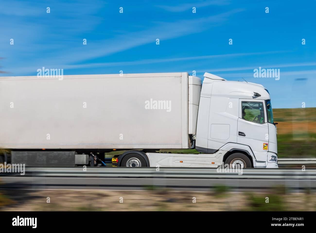 Lkw mit gekühltem Auflieger mit Geschwindigkeitseffekt und der Rest des Bildes ist verschwommen. Stockfoto