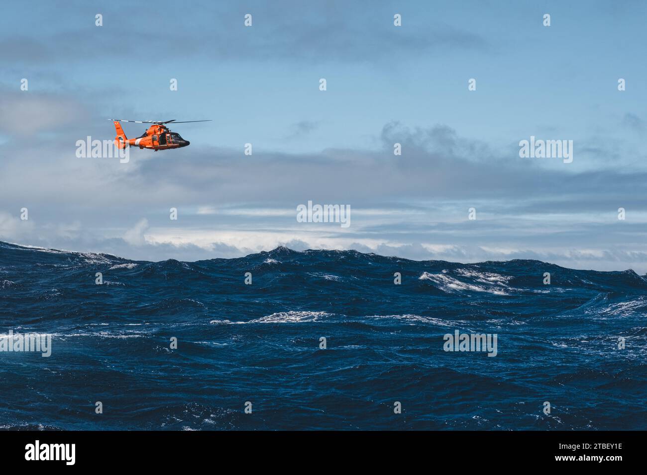 Eine H-65 von der Air Station Barbers Point schwebt über den Gewässern vor der Nordküste von Oahu, Hawaii. Die Air Station Barbers Point führte am 5. Dezember 2023 ein Rettungsschwimmer-Training durch, mit einem unter Vertrag stehenden Schiff der Küstenwache. Stockfoto