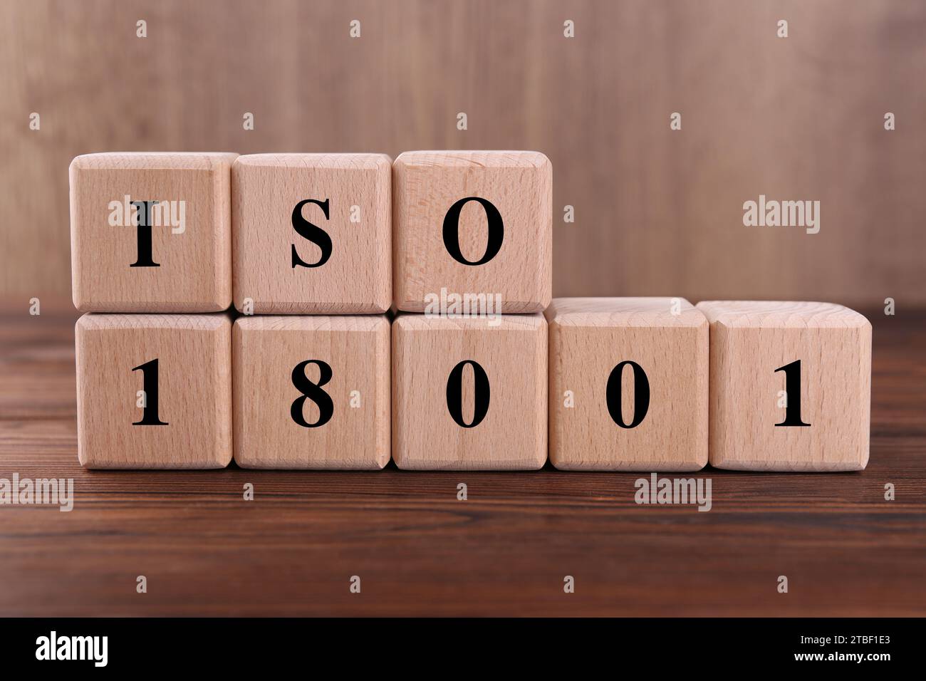 Würfel mit der Abkürzung ISO und der Nummer 18001 auf Holztisch Stockfoto
