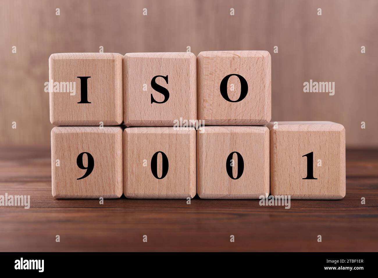 Würfel mit der Abkürzung ISO und der Nummer 9001 auf Holztisch Stockfoto