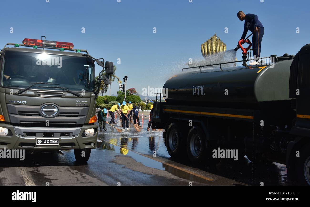 Junge Vertreter der Royal Thai Army helfen anderen bei einem nationalen Aufräumtag in Nakhon Phanom, Thailand, Südostasien. Der 5. Dezember ist ein Nationalfeiertag, da er an den Geburtstag des verstorbenen Königs Bhumibol Adulyadej, Rama 9, erinnert. Diese Veranstaltung beginnt mit einer Parade für Fotos und kurze Reden, gefolgt von allen, die Zweigbürsten und Wassertanker verwenden, um die Straßen sauber zu fegen. Der Tag wird in Thailand als Vatertag bezeichnet. Stockfoto