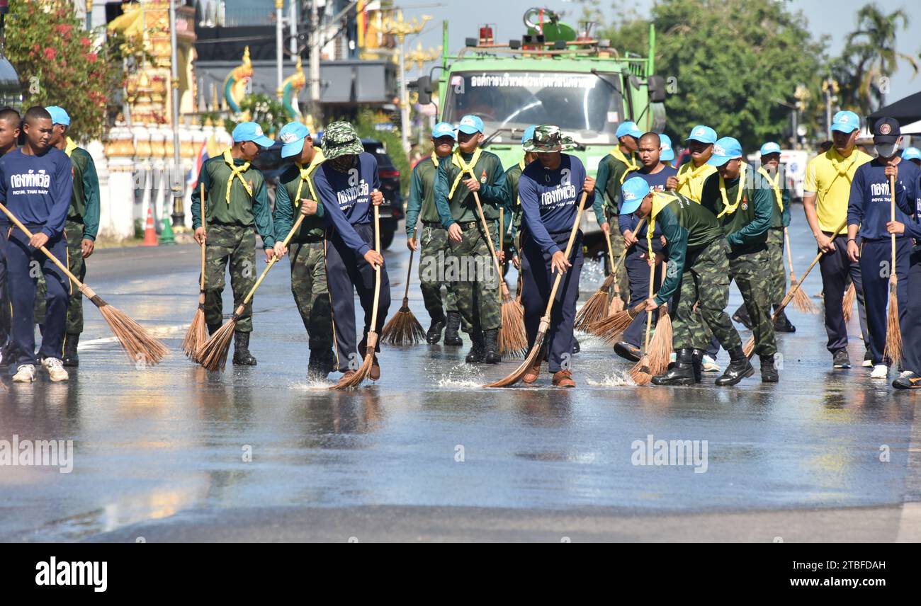 Junge Vertreter der Royal Thai Army helfen anderen bei einem nationalen Aufräumtag in Nakhon Phanom, Thailand, Südostasien. Der 5. Dezember ist ein Nationalfeiertag, da er an den Geburtstag des verstorbenen Königs Bhumibol Adulyadej, Rama 9, erinnert. Diese Veranstaltung beginnt mit einer Parade für Fotos und kurze Reden, gefolgt von allen, die Zweigbürsten und Wassertanker verwenden, um die Straßen sauber zu fegen. Der Tag wird in Thailand als Vatertag bezeichnet. Stockfoto