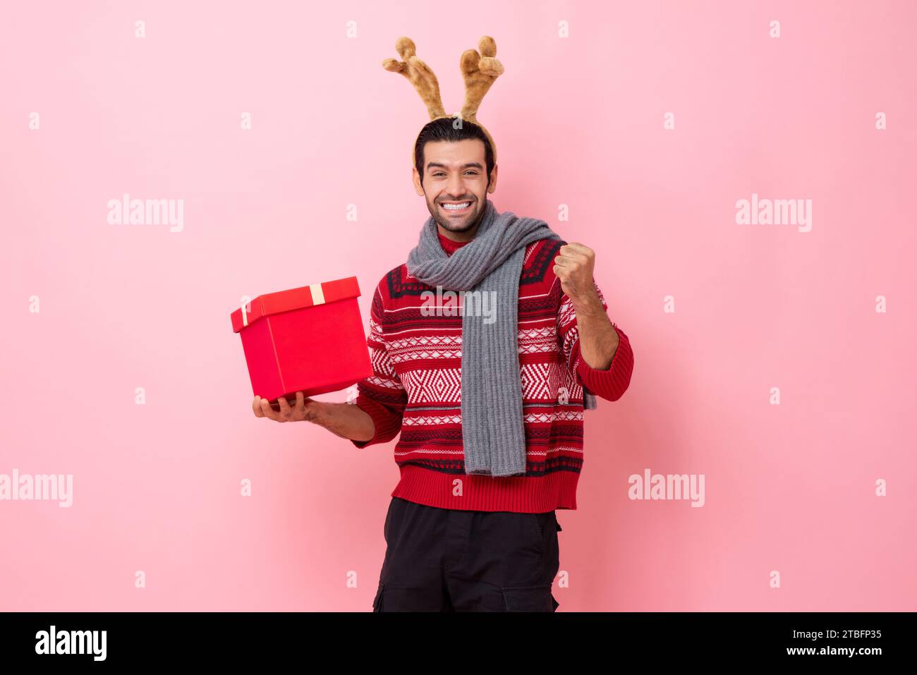 Überraschter aufgeregter Kaukasier in Weihnachtskleidung mit Geschenkbox, festliches Studio-Porträt in rosa Farbe isolierter Hintergrund Stockfoto