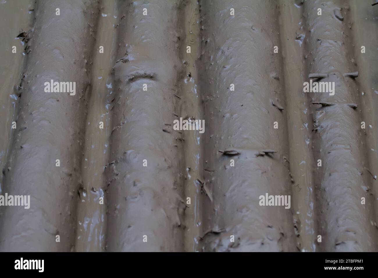 Ungewöhnlicher Holzhintergrund (schmutziges Holz). Baumstämme werden auf der Straße gelegt und gleichmäßig mit Schlamm bedeckt. Stockfoto