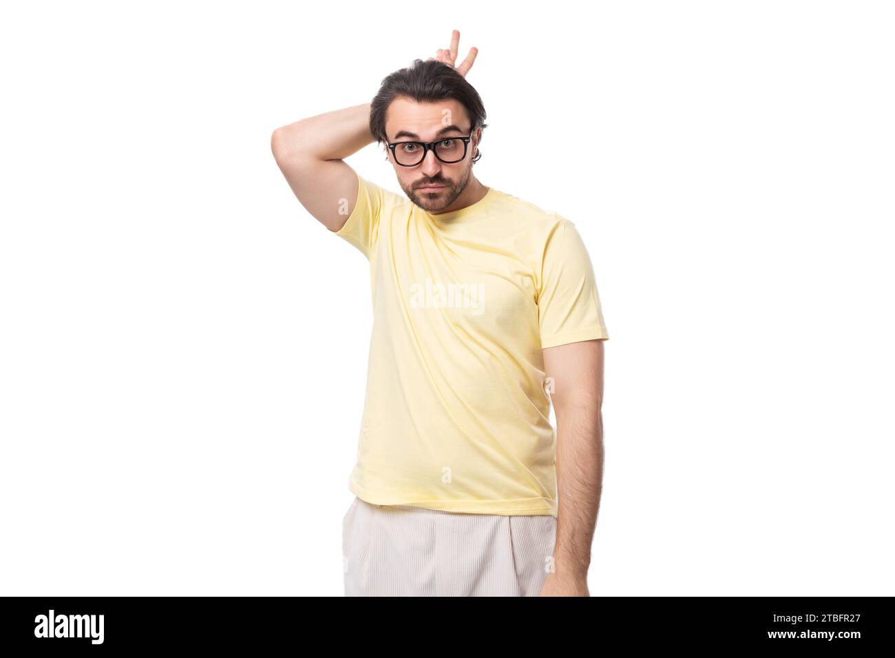 Junger kaukasischer Mann mit schwarzem Haar und Bart zeigt Grimasse Stockfoto